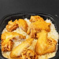Fried Chicken Wings On Rice & Gravy Soul Food Meal · Three whole wings on a large bed of rice and gravy and roll.