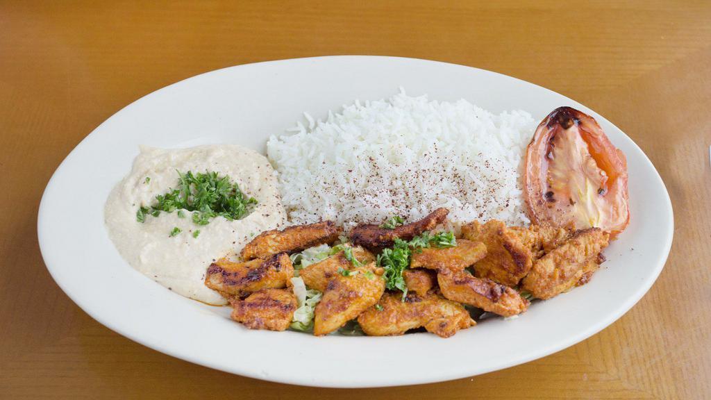 Chicken Sheesh Tawook Plate · A generous amount of grilled chicken breast marinated with lemon juice, garlic, and special spices. Served with garli, a side of hummus, a house salad, pita bread, and available in spicy.