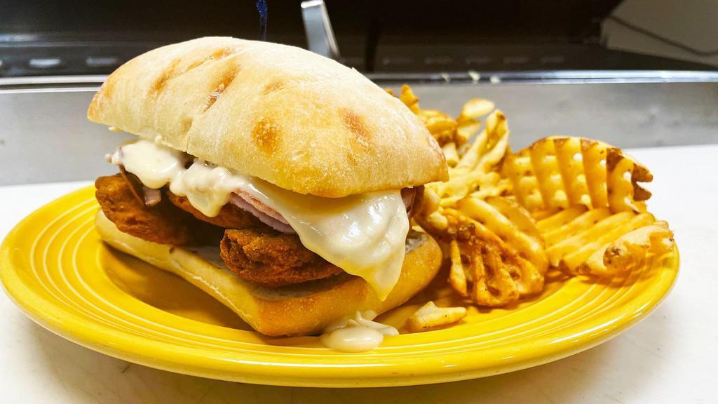 Chicken Cordon Bleu · Crispy chicken tenders topped with grilled slices of ham and house made gouda cream sauce.  Served on a toasted ciabatta roll.