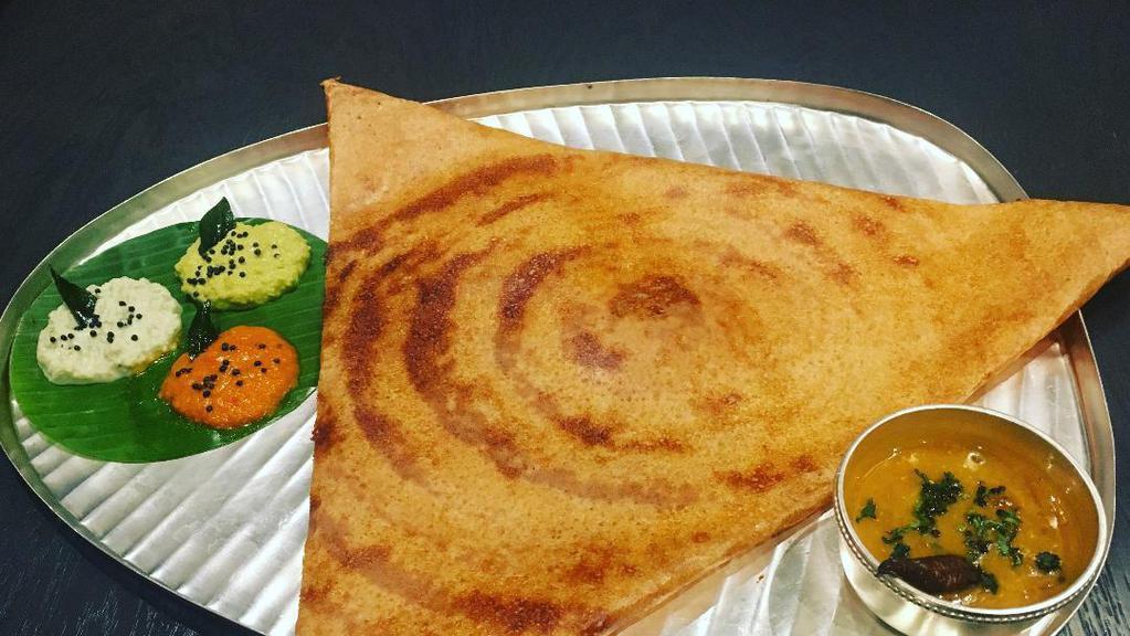 Mysore Dosa · Red chili chutney spread on thin rice and lentil crepe. Served with three varieties of chutneys and sambar.
