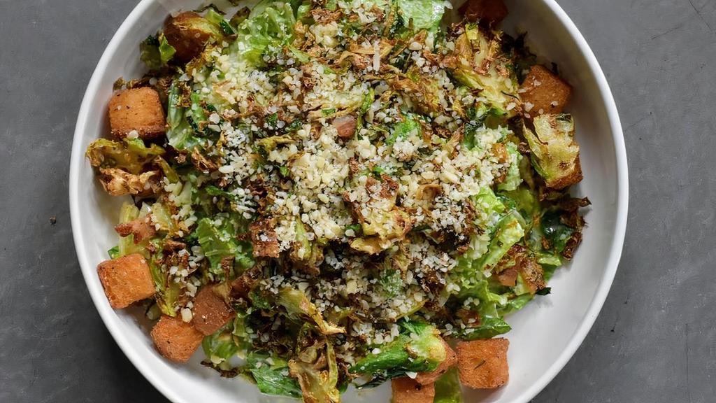 Chomp Caesar · Chopped romaine tossed in chomp Caesar dressing, topped with crispy shredded brussels sprouts, parmesan peppercorn bacon, and grated parmesan cheese