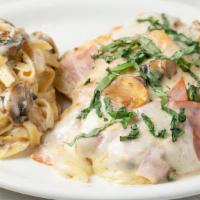 Chicken Milano · Sautéed chicken breast with mushrooms and Alfredo sauce topped with ham, Provolone cheese an...