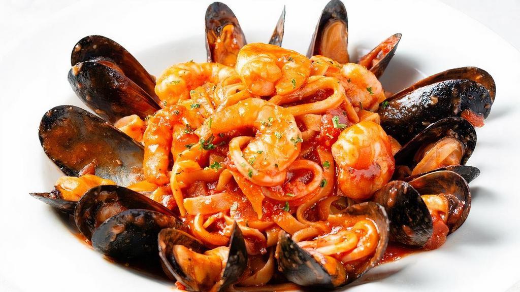 Seafood Fettuccine · Tender calamari, shrimp and mussels sautéed with fresh garlic and tossed in fettuccine with spicy marinara or Alfredo sauce.