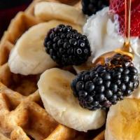 Waffles W/ Fruit · Belgian waffles served with various fruits and berries topped with syrup and whipped cream.
