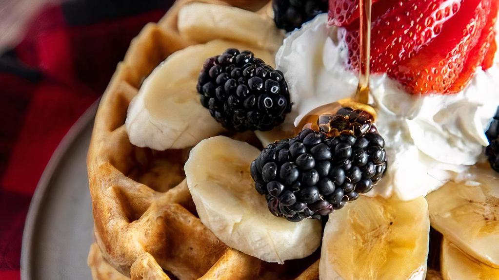 Waffles W/ Fruit · Belgian waffles served with various fruits and berries topped with syrup and whipped cream.