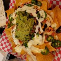 Loaded Nachos · Yellow corn tortilla chips covered with our homemade black bean salsa, cheese, jalapenos, to...