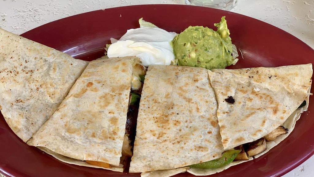 Fajita Quesadilla · Grilled flour tortilla wedges stuffed with cheese, onions, bell peppers, mushrooms, zucchini, tomatoes choice of grilled chicken or carne asada and served with sour cream and guacamole.