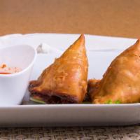 Samosas (2 Pcs) · Pastry stuffed with potato, peas, onions cooked in aromatic spices, served with green sauce.