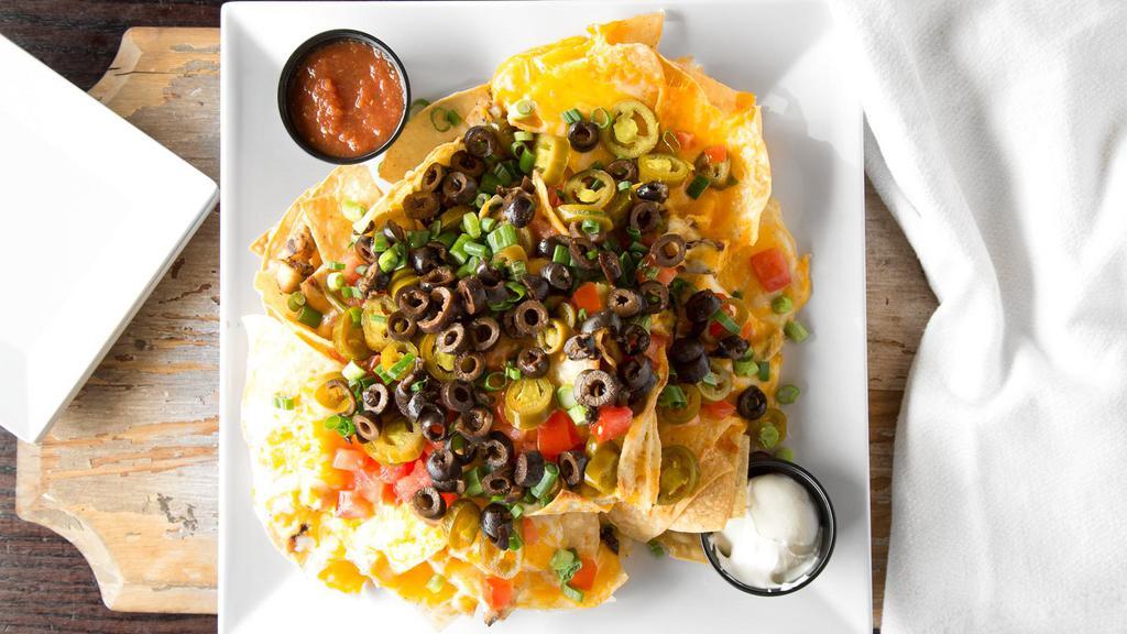 Over The Top Nachos · Fresh tortilla chips covered with our house made queso, diced tomatoes, black olives, green onions, jalapeños, melted cheddar jack cheese and your choice of diced chicken or beef. Served with sour cream and house made salsa.