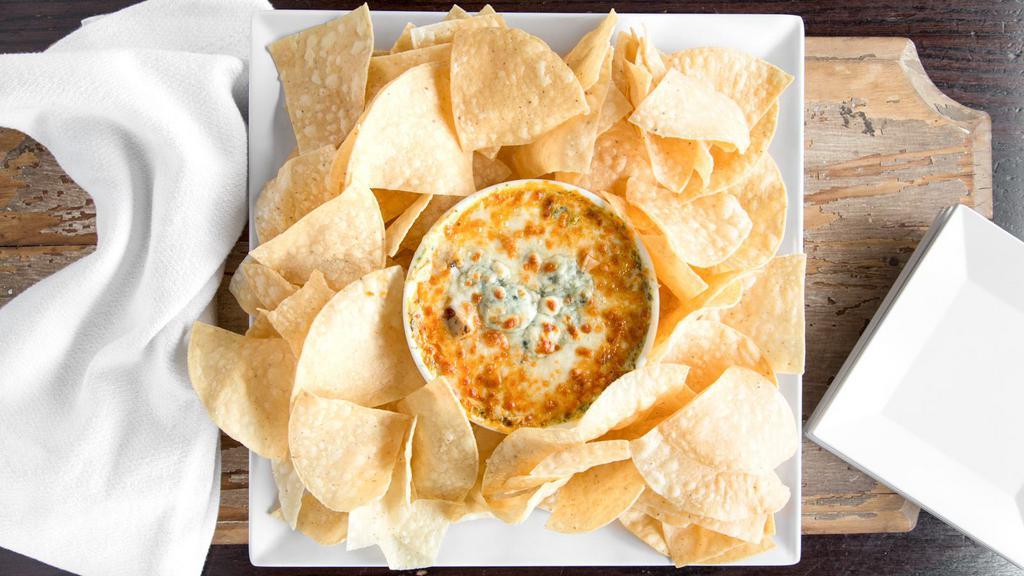 Buffalo Chicken Spinach Dip · Grilled chicken diced and tossed in regular wing sauce and blended with our house made spinach dip. Topped with melted provolone, mozzarella and bleu cheese crumbles. Served with fresh tortilla chips.
