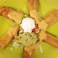 Flautas De Pollo · Crisp corn tortillas stuffed with seasoned chicken; served with cheese, guacamole, and sour ...