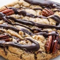 Turtle · Cookie stuffed with pecans, caramel bits, chocolate chips, and finished with a chocolate dri...