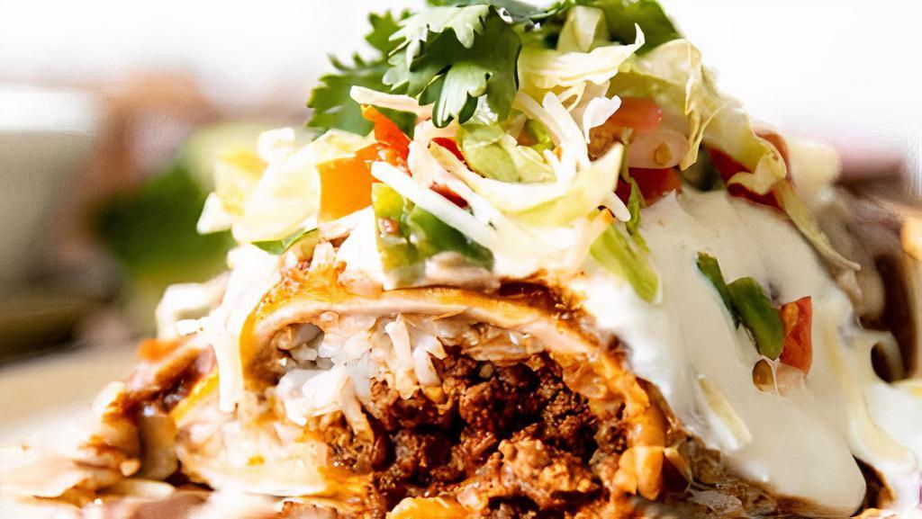 Steak Burrito · Steak and refried beans rolled up in a flour tortilla, topped with cheese, lettuce, tomatoes and sour cream.