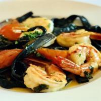 Tagliatelle Nere Al Gamberi · Handmade black ribbon pasta, sautéed shrimp, garlic, chilies, lemon juice, tomato and parsley.