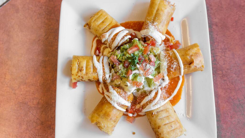 Chicken Taquitos · Crispy corn or flour tortillas filled with shredded chicken and cheese. Garnished with tomatoes, sour cream, parmesan cheese, and guacamole.