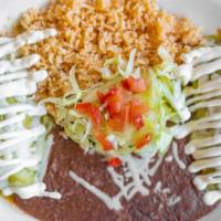 Enchiladas Suizas · Corn tortillas filled with shredded chicken, topped with green sauce, sour cream, and served...