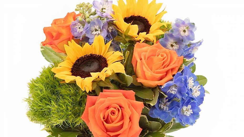 Seaside Sunflower Bouquet · Imagine the warmth and brilliance of a sun-splashed summer day. Those are the thoughts expressed by this creatively crafted arrangement of sunflowers, roses, delphinium, green tick and pittosporum.