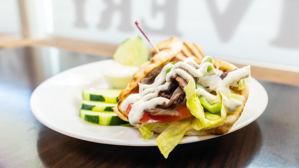 Beef Gyro Sandwich · Thinly sliced beef, peppers, sautéed onions, roasted peppers, creamy tzatziki sauce, and served on a warm pita.