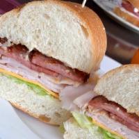 Turkey Club · Smoked turkey breast, bacon, American cheese, lettuce, tomatoes, and mayonnaise on a hero.