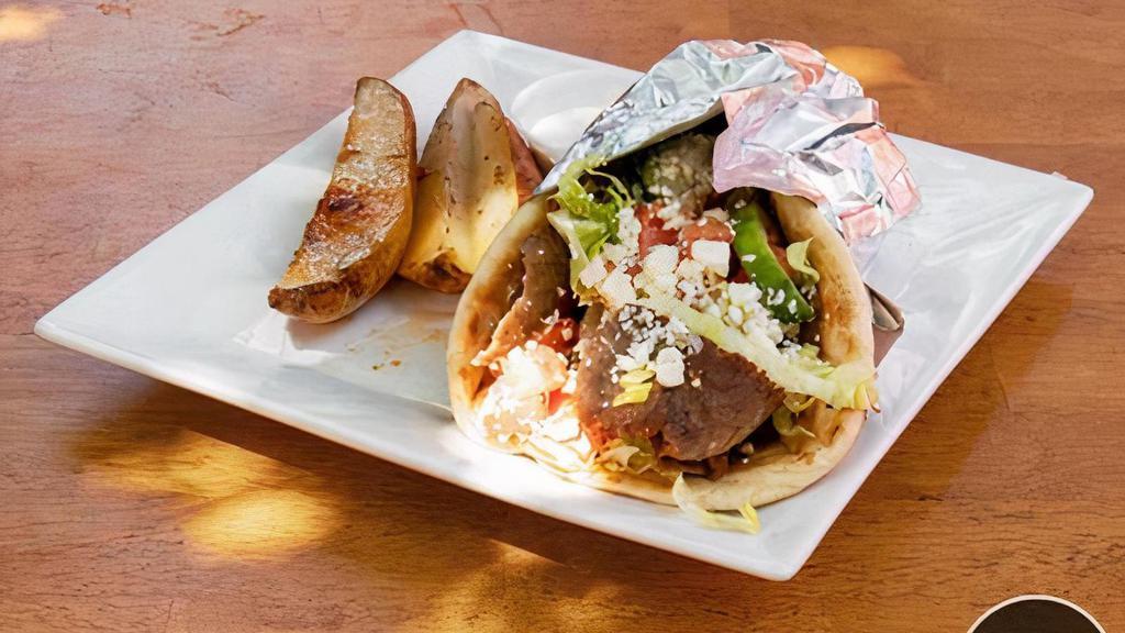 Gyro Sandwich · Beef and lamb gyro shaved in a pita with lettuce, tomatoes, onions, parsley, feta cheese, and tzatziki sauce.