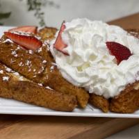 French Toast · Thick brioche bread topped with powdered sugar, strawberries and whipped cream.