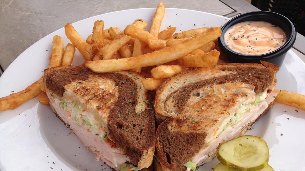 Turkey Reuben · Fresh roasted turkey served on grilled marble rye with swiss cheese and coleslaw. Served with 1000 island dressing and homemade potato chips.