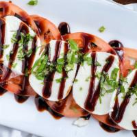 Stacked Caprese Salad · Fresh sliced tomatoes topped with fresh sliced mozzarella cheese, basil and balsamic reducti...