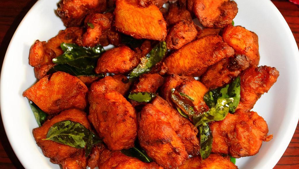 Kozhi Porichathu (Chicken 65) · Chicken nuggets marinated with chili paste and curry leaves.