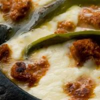 Queso Flameado · Sizzling skillet with melted cheese, sautéed onions, bell peppers, tomatoes and topped with ...