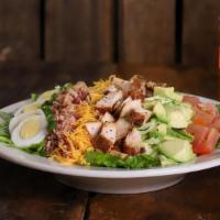 Chicken Cobb Salad · Smoked chicken breast on a bed of romaine/iceberg mix topped with avocado, bacon, egg, chedd...