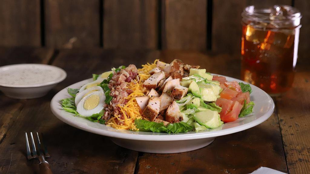 Chicken Cobb Salad · Smoked chicken breast on a bed of romaine/iceberg mix topped with avocado, bacon, egg, cheddar cheese, fresh-cut chives and tomatoes. Served with your choice of dressing on the side.