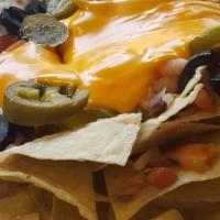 Nachos · Classic nachos topped special blend of cheese, jalapeños and freshly chopped green onions, t...