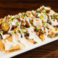 Bbq Chicken Nachos · House fried flour tortilla chips topped with queso, chicken, bacon, black bean corn salsa, j...