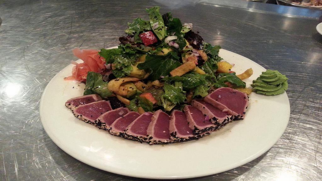 Seared Ahi Tuna Salad · Seared, sesame-crusted ahi tuna accompanied by fresh field greens, mango, avocado, red peppers, red onions, and wonton strips tossed in our honey sesame vinaigrette. Garnished with pickled ginger and wasabi.
