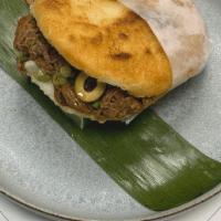 Ropa Vieja · White corn cake stuffed with braised flaked steak and green olives