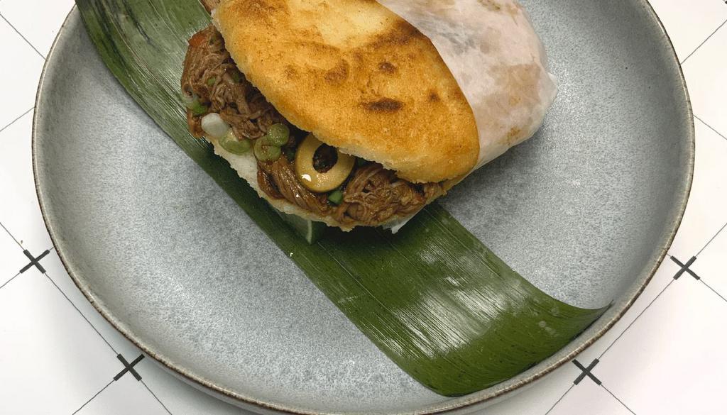 Ropa Vieja · White corn cake stuffed with braised flaked steak and green olives