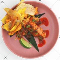 Salmon Anticuchos · Grilled Salmon skewers marinated with ají panca and lime. Served with crispy root chips.