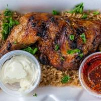Whole Grilled Chicken Over Rice · Whole grilled Chicken over rice with hot sauce and garlic sauce