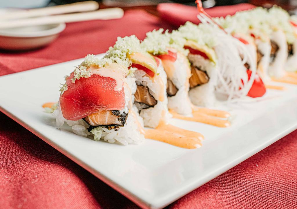 Lovers Roll · Spicy salmon inside and sliced tuna avocado on top with tempura flakes. Raw fish.