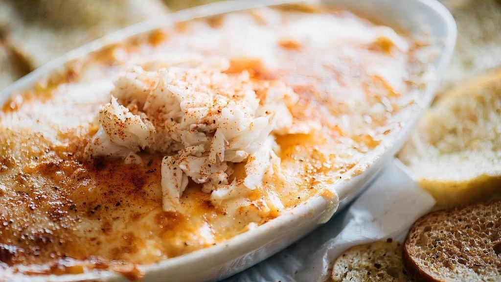 Crab & Artichoke Dip · lump crab meat, artichoke hearts, house blend cheese, served with parmesan crostini