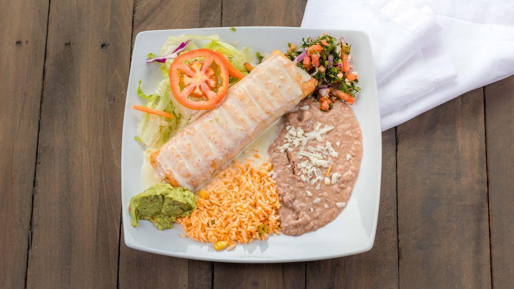 Chimichanga · Choice of seasoned ground beef or seasoned shredded chicken in a 10” flour  tortilla, deep-fried to a golden brown. Topped with cheese sauce, lettuce, sour cream, guacamole and pico de gallo.