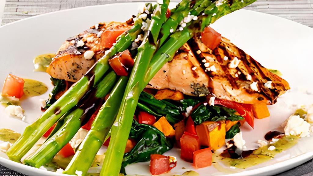 Grilled Salmon Fresca · Norwegian salmon, asparagus, sweet potatoes, spinach, red peppers, pesto vinaigrette, feta, tomatoes, balsamic glaze.