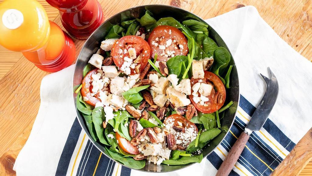Side Spinach Salad · Fresh baby spinach topped with Roma tomatoes, feta cheese, and Texas pecans. Try adding grilled chicken and cranberries.