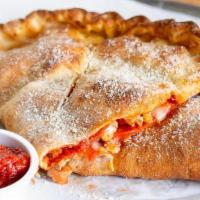 Pepperoni & Sausage Calzone · Red sauce base, mozzarella, house pepperoni, sage sausage, and topped with grated parmesan c...