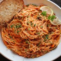 Bolognese · Local butcher ground beef meat sauce
with a swirl of cream served over spaghetti.