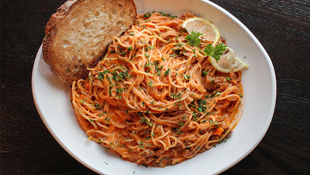 Bolognese · Local butcher ground beef meat sauce
with a swirl of cream served over spaghetti.