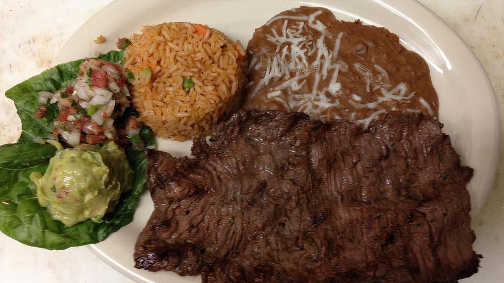 Carne Asada · Grilled marinated skirt steak served with rice and beans along with a side of guacamole, pico de gallo and your choice of tortillas.
