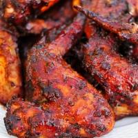 Spicy Grilled Chicken Wings · Cilantro ranch and pickled carrots.