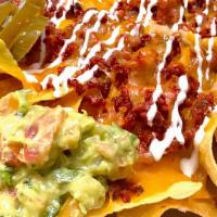 Nachos De La Casa · Homemade  made to order tortilla chips with melted shredded cheese, your choice of meat, Mex...