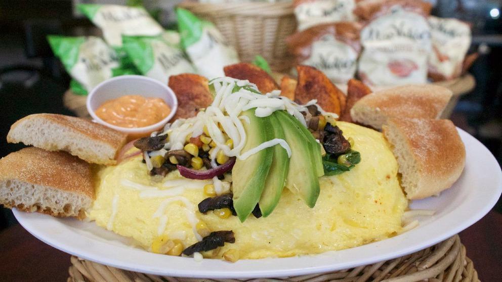 Vegetarian Omelette · Spinach, onions, tomatoes, corn, mushrooms, and mozzarella. A 3 egg omelette served with homemade strawberry jelly and ciabatta bread.